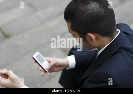 Businessman Holding and Dialing a Cell Phone Stock Photo