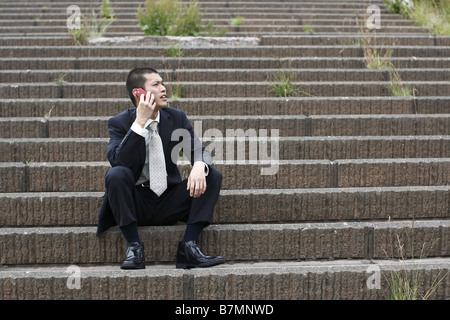 Businessman on Cellphone Sitting on Steps Stock Photo