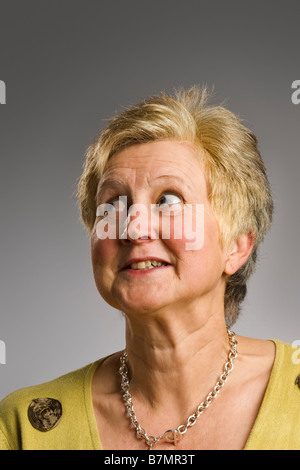 Mature woman looking away from camera with humorous face Stock Photo