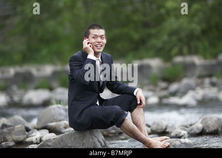 Smiling Businessman Talking on Cell Phone at River Stock Photo