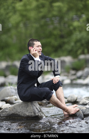 Businessman Talking on Cell Phone at River Stock Photo