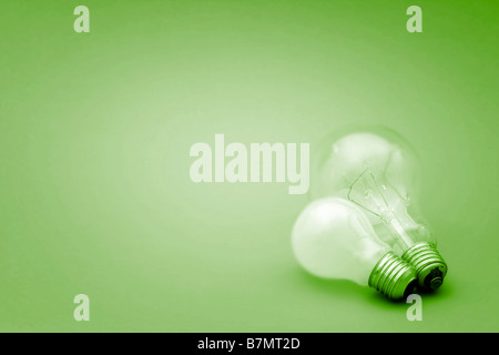 Background with lit lightbulb on green Stock Photo