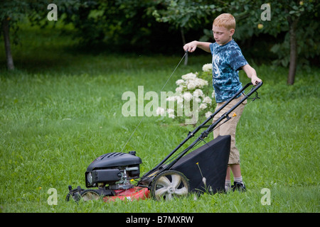 Teenage Boy Starting Up Lawn Mower Stock Photo