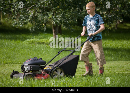Teenage Boy Pushing Lawn Mower Stock Photo