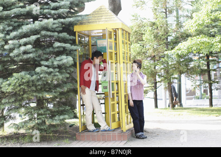 Couple on Phone in the Park Stock Photo