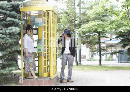 Couple on Phone in the Park Stock Photo