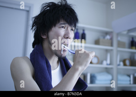 Man Brushing Teeth in a Bathroom Stock Photo