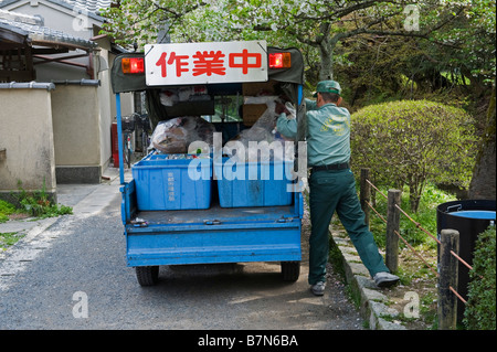 Kyoto, Japan. Collecting refuse underneath the cherry blossom in spring Stock Photo
