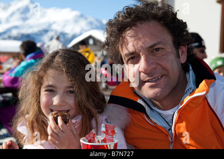 Father and daughter at the chalet restaurant on the slopes. Bormio, Valtellina, Italy Stock Photo