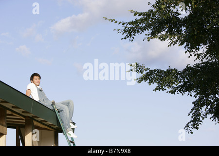 A man sitting on the roof Stock Photo