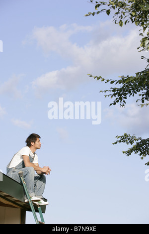 A man sitting on the roof Stock Photo