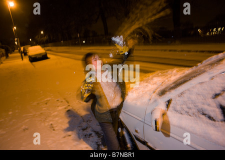 A boy plays snowballs at night during heavy snow showers in central London, a rare event for a southern inner-city Stock Photo