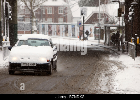 Snow covers cars driving past East Finchley Underground Station north London on the 2nd of February 2009 Stock Photo