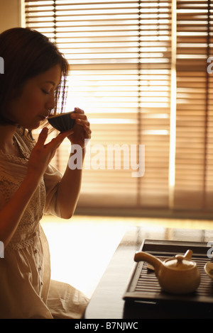 A woman drinking a cup of tea Stock Photo
