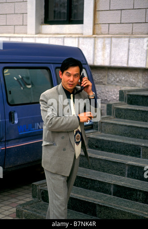 People male 1 one adult man talking on cell phone conducting business businessman Kunming Yunnan Province China Asia Stock Photo