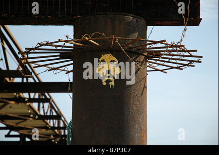 A face representing Jesus Christ spray painted on the rusty remains of the West Pier, Brighton, Sussex, UK. Stock Photo