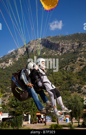 A paragliding student and instructor in a tandem paraglider  just coming in to land on a beach near  Fethiye, Turkey Stock Photo