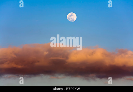 Moon in blue sky in evening above cloud seen from Canary Islands Spain Stock Photo