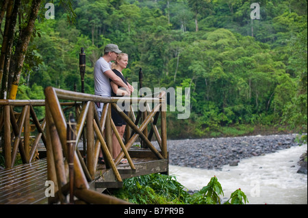 Central America, Costa Rica. A couple enjoys the view from a lodge on the Pacuare River. Stock Photo