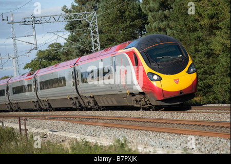 Class 390 Pendolino train speeding along track on the West Coast Main Line England Stock Photo