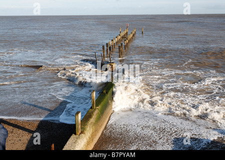 Waves crash against wooden groyne Coastal defences Lowestoft Suffolk England Stock Photo
