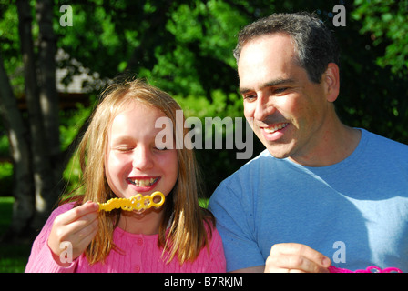 Happy family blowing soap bubbles and laughing Stock Photo