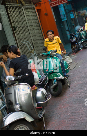 Trendy young Thai s hanging out with the popular classic Vespa scooter Chinatown in central Bangkok Thailand Stock Photo