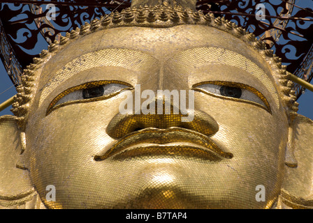 Face of 32m golden standing buddha buddhist temple Wat Intharavihan in Dusit district of Bangkok in Thailand Stock Photo