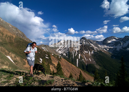 a backpacker on a ridge with his dog high up in the san juan mountains of colorado near telluride Stock Photo