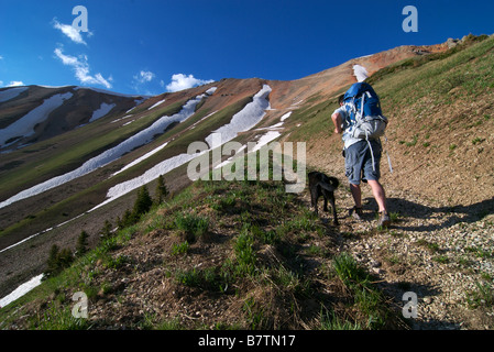 a backpacker on a ridge with his dog high up in the san juan mountains of colorado near telluride Stock Photo