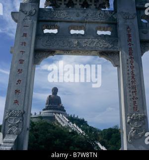 Big Buddha Seated statue on hill Hand raised Steep steps Framed by stone carved gate PO LIN MONASTERY LANTAU ISLAND HONG KONG Stock Photo