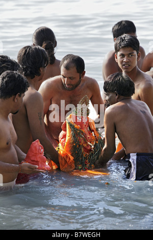 Men sinking Ganesh Chaturthi statue during festival Stock Photo