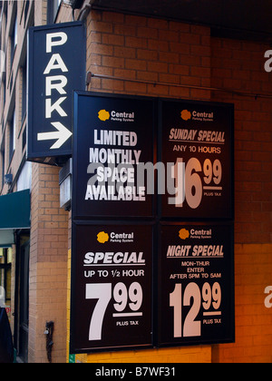 A sign containing pricing information at the entrance to a typical urban parking garage or pay lot. Stock Photo