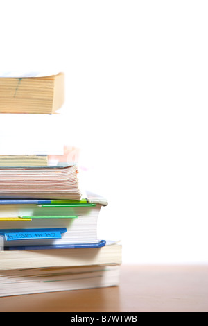 A stack of books sitting on the corner of a desk Stock Photo
