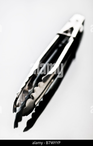 Kitchen tongs isolated on white Shallow depth of field Stock Photo
