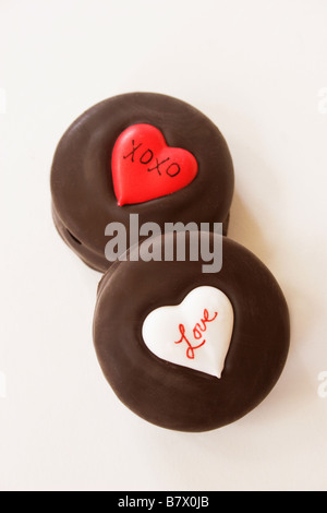 Two Valentine chocolate cookies with heart designs, on a white background. Stock Photo