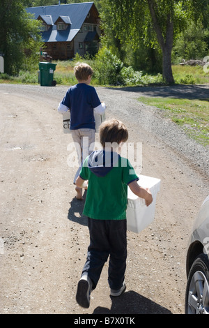 two boys holding boxes, preparing to release a wild animal back into the forest Stock Photo