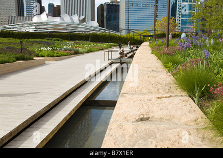 ILLINOIS Chicago Hardwood footbridge and stream that divides Lurie Garden in Millennium Park Stock Photo