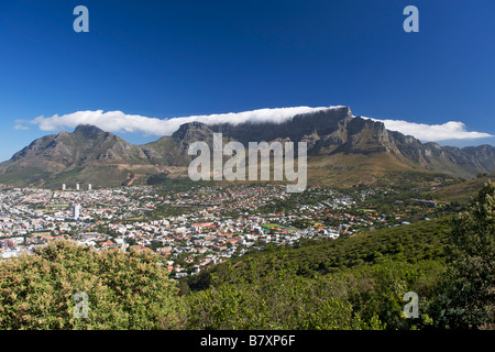 View of the city of Cape Town surrounded by Table Mountain on which the clouds create the well-known 'table cloth' effect. Stock Photo