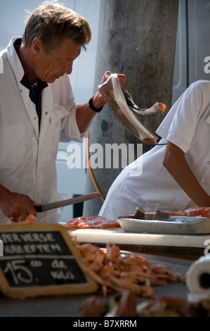 Fishmonger prepares fish produce at the fish market in Bruges Brugge West Flanders Belgium Stock Photo