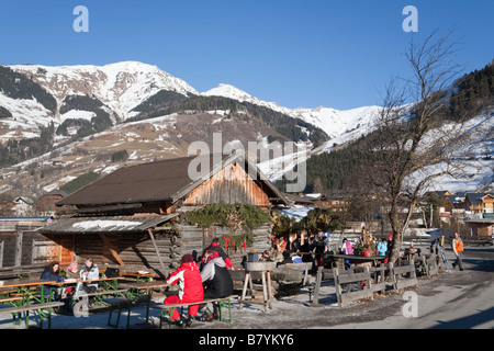 Rauris Raurisertal Austria Europe January People sitting outside ski resort cafe in Austrian Alps in winter sunshine Stock Photo