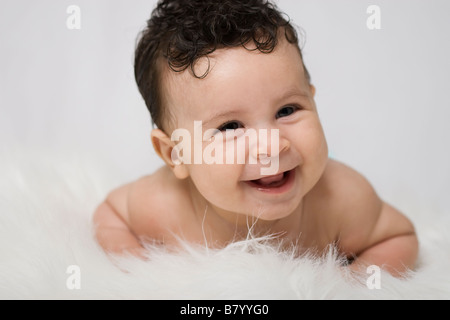 Portrait of a Hispanic Baby laughing Looking away from camera Stock Photo