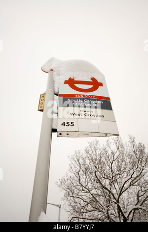 A snowy bus stop sign in London. Stock Photo