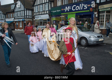 London May Queen and retinue in procession through a suburban High Street in South-East London Stock Photo