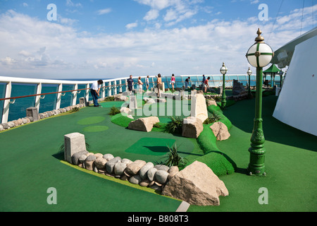 Cruise guests play miniature golf on the deck of the Royal Caribbean Navigator of the Seas cruise ship Stock Photo