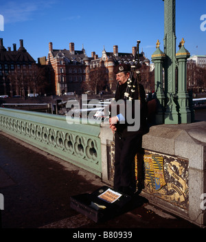 Man playing the bagpipes on Westminster Bridge London England UK Stock Photo