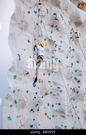 Teenage boy climbing artificial rock wall onboard Royal Caribbean Navigator of the Seas cruise ship Stock Photo