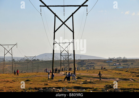 Electricity transmission lines march across the landscape in the townships of Grahamstown, South Africa Stock Photo