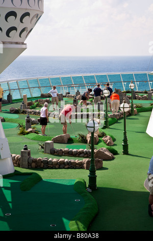 Cruise guests play miniature golf on the deck of the Royal Caribbean Navigator of the Seas cruise ship Stock Photo