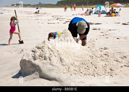 Man builds shark shaped sand sculpture on beach at Port St. Joe Florida, USA Stock Photo